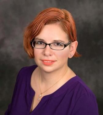 professional photo of Connie with orange-ish hair and wearing a royal purple top